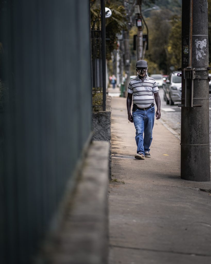 man in blue denim jeans walking on sidewalk during daytime