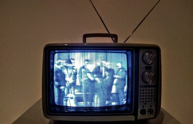 black crt tv turned on on white table