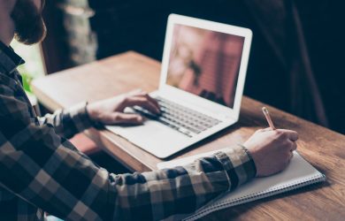 Osoba pracująca przy użyciu laptopa i notesu